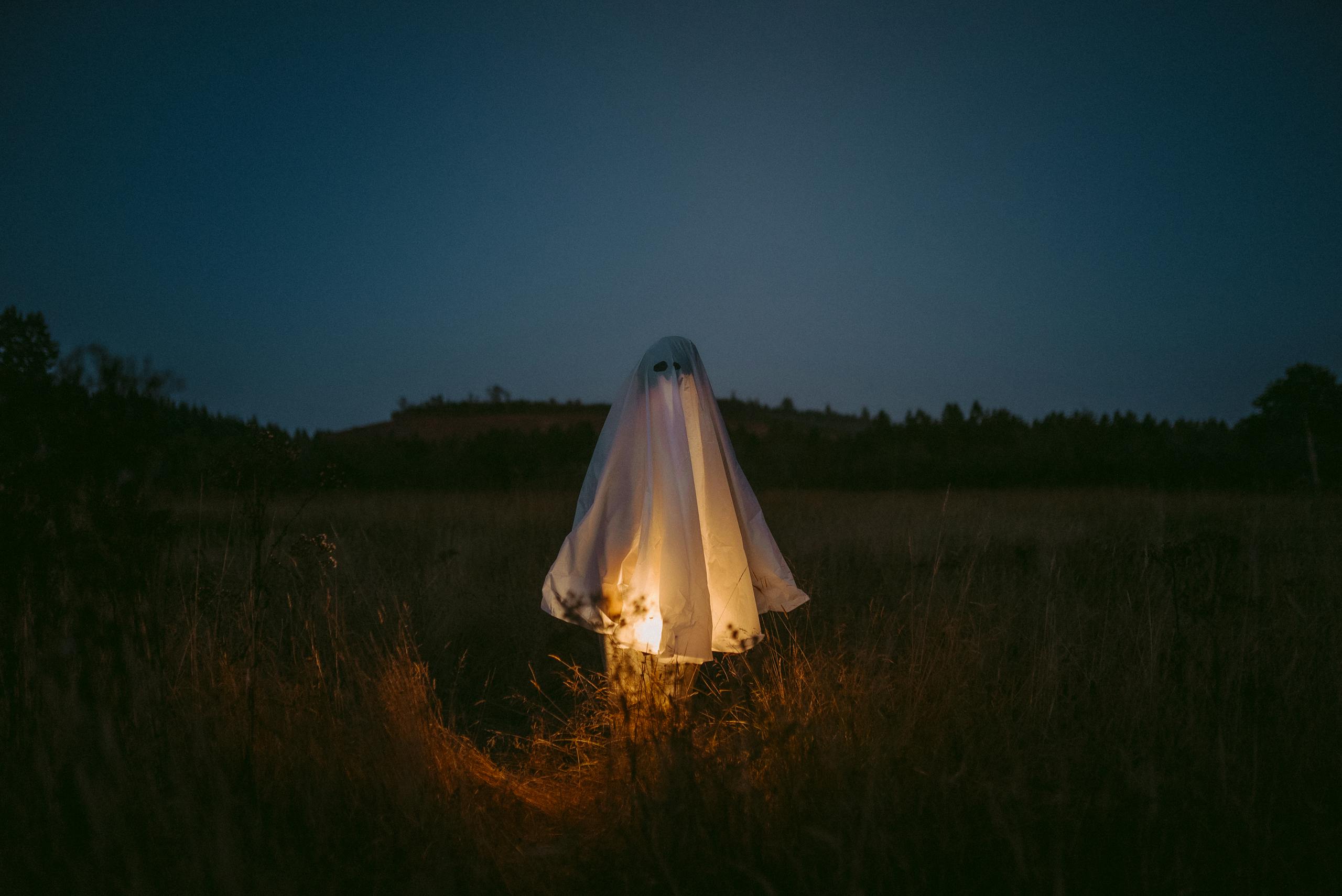 A ghostly figure illuminated in a dark field captures the Halloween spirit.
