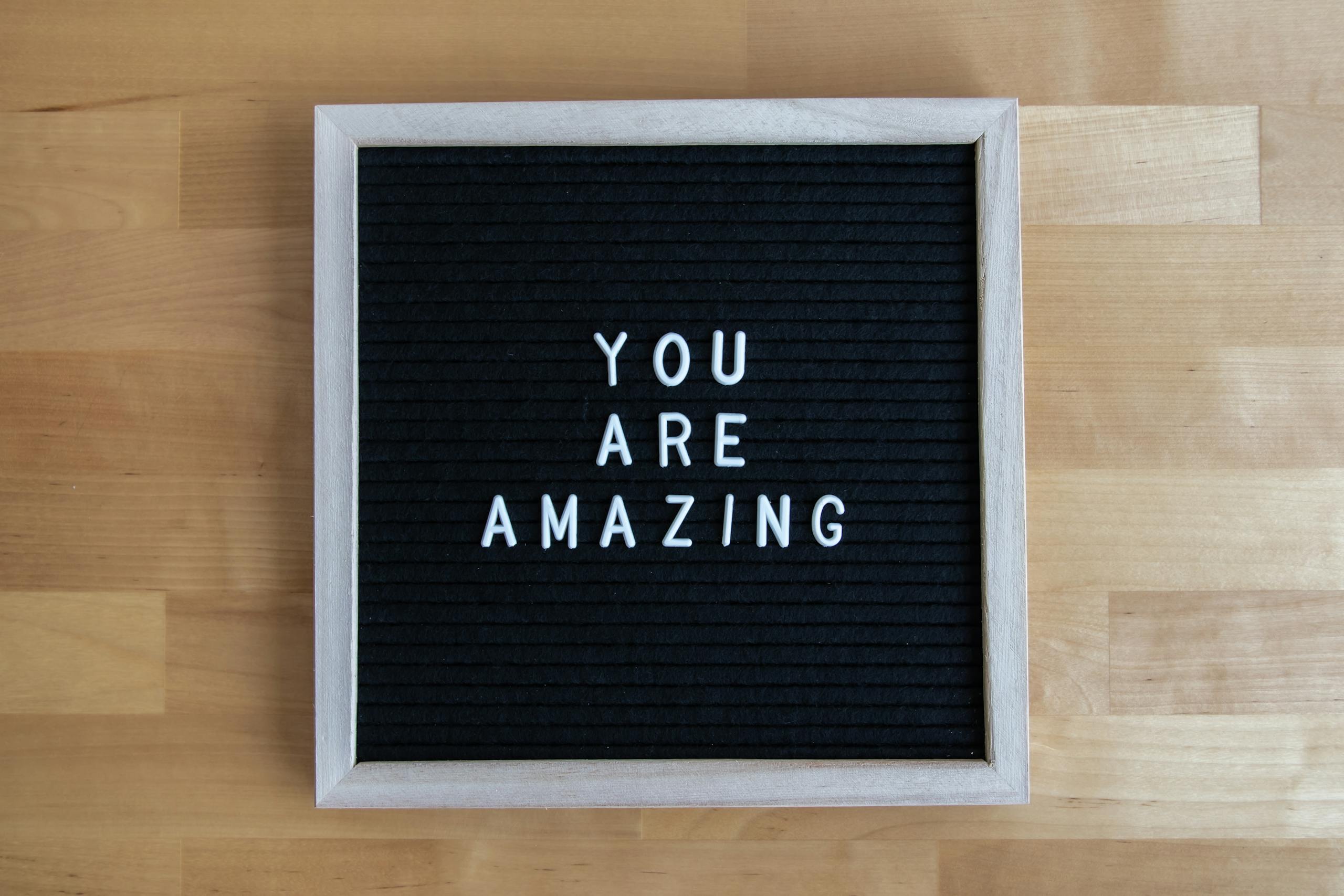 Letter board displaying 'You Are Amazing' on a wooden table, conveying motivation.